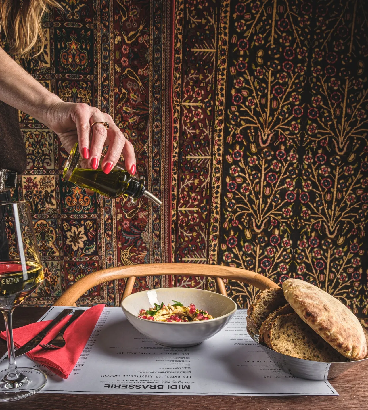 Houmous au zaatar et pain pita, huile d’olive versée à table