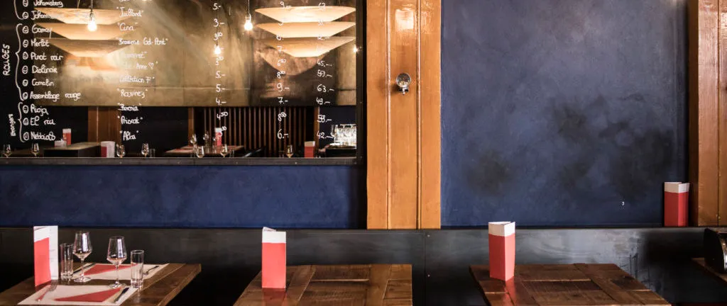La salle de la brasserie, murs bleu nuit et photophores rouges